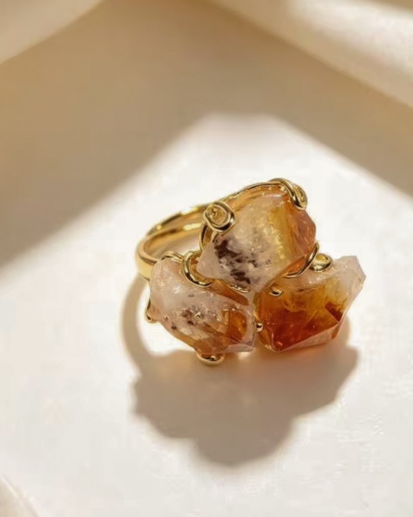 Sol — raw crystal ring with three honey and amber toned natural stones in a gold-toned setting